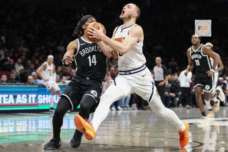 Jan 4, 2026; Brooklyn, New York, USA;  Denver Nuggets guard Christian Braun (0) looks to drive past Brooklyn Nets guard Terance Mann (14) in the first quarter at Barclays Center. Credit: Wendell Cruz-Imagn Images