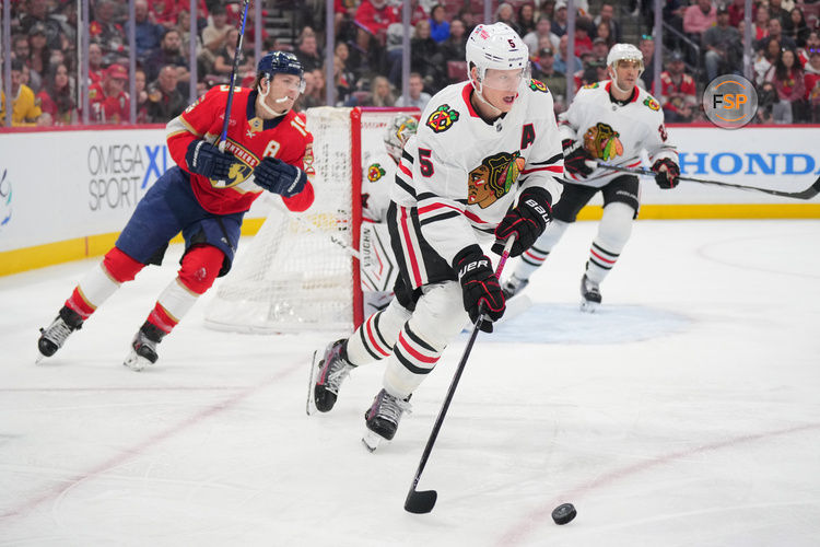 Feb 1, 2025; Sunrise, Florida, USA; Chicago Blackhawks defenseman Connor Murphy (5) clears the zone as Florida Panthers left wing Matthew Tkachuk (19) follows on the play in the second period at Amerant Bank Arena. Credit: Jim Rassol-Imagn Images