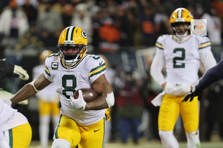 Dec 20, 2025; Chicago, Illinois, USA; Green Bay Packers running back Josh Jacobs (8) runs the ball and quarterback Malik Willis (2) watches the play against the Chicago Bears during the third quarter at Soldier Field. Credit: Mike Dinovo-Imagn Images