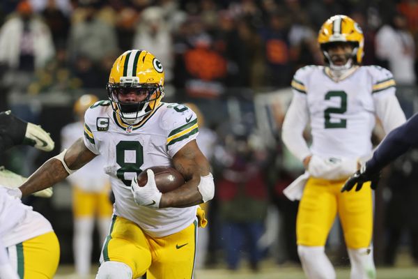 Dec 20, 2025; Chicago, Illinois, USA; Green Bay Packers running back Josh Jacobs (8) runs the ball and quarterback Malik Willis (2) watches the play against the Chicago Bears during the third quarter at Soldier Field. Mandatory Credit: Mike Dinovo-Imagn Images