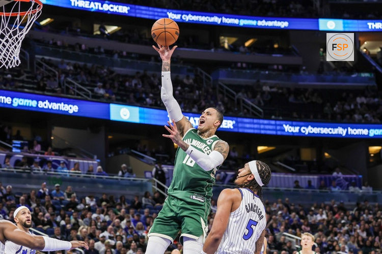 Feb 11, 2026; Orlando, Florida, USA; Milwaukee Bucks forward Kyle Kuzma (18) goes to the basket against Orlando Magic forward Paolo Banchero (5) during the first quarter at Kia Center. Credit: Mike Watters-Imagn Images