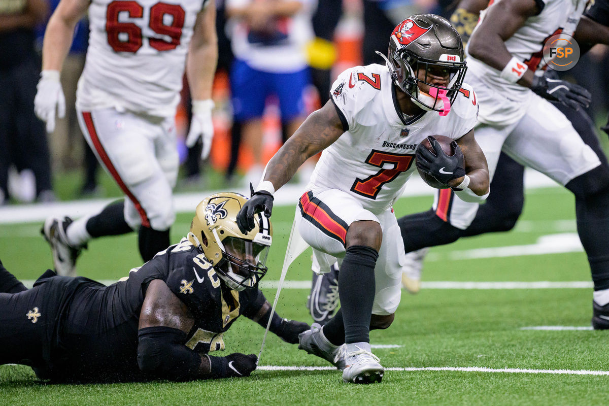 Oct 13, 2024; New Orleans, Louisiana, USA; New Orleans Saints defensive tackle Khalen Saunders (50) attempts to tackle Tampa Bay Buccaneers running back Bucky Irving (7) with a a piece from his shirt during the second quarter at Caesars Superdome. Credit: Matthew Hinton-Imagn Images