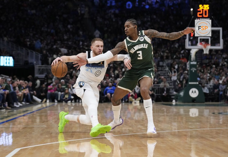 Apr 8, 2025; Milwaukee, Wisconsin, USA;  Minnesota Timberwolves guard Donte DiVincenzo (0) drives against Milwaukee Bucks guard Kevin Porter Jr. (3) in the first half at Fiserv Forum. Credit: Michael McLoone-Imagn Images