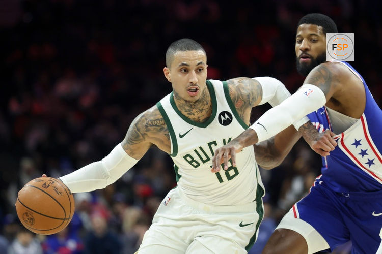 Jan 27, 2026; Philadelphia, Pennsylvania, USA; Milwaukee Bucks forward Kyle Kuzma (18) drives past Philadelphia 76ers forward Paul George (8) during the first quarter at Xfinity Mobile Arena. Credit: Bill Streicher-Imagn Images