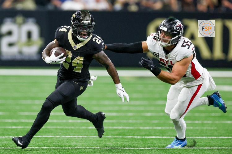 Nov 23, 2025; New Orleans, Louisiana, USA; New Orleans Saints running back Devin Neal (24) carries the ball as Atlanta Falcons linebacker Kaden Elliss (55) defends during the second half at Caesars Superdome. Credit: Stephen Lew-Imagn Images
