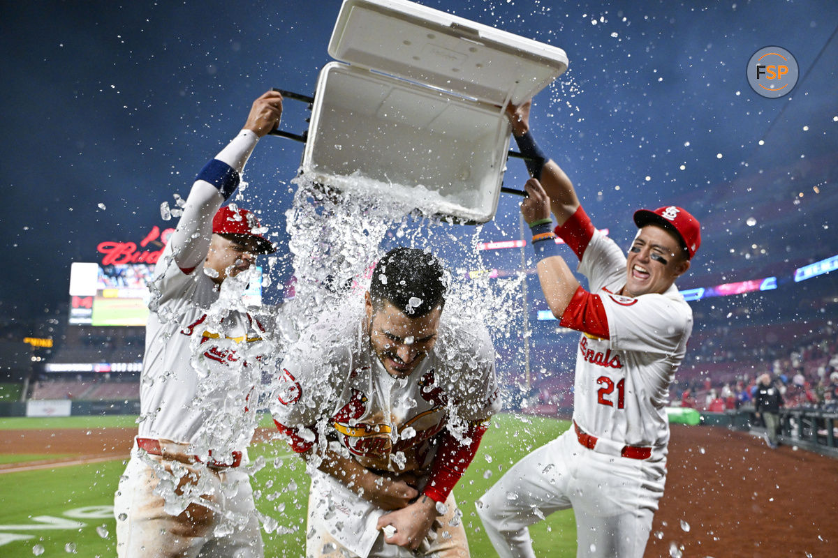 Aug 21, 2024; St. Louis, Missouri, USA;  St. Louis Cardinals third baseman Nolan Arenado (28) is doused with water by shortstop Masyn Winn (0) and center fielder Lars Nootbaar (21) after hitting a walk-off grand slam against the Milwaukee Brewers during the tenth inning at Busch Stadium. Credit: Jeff Curry-USA TODAY Sports