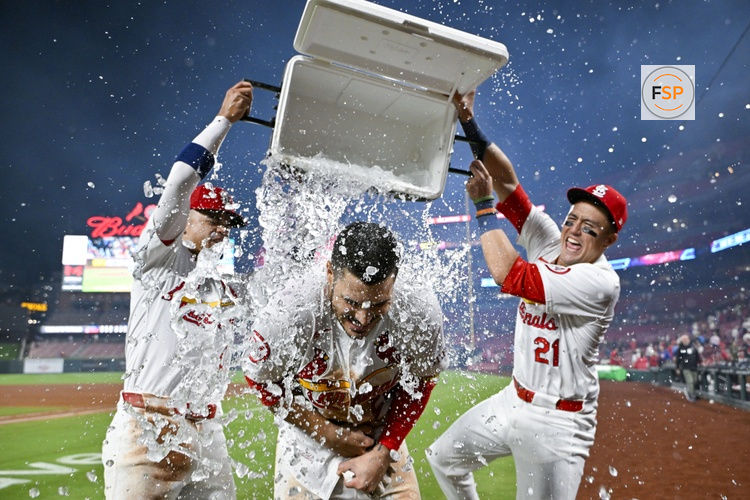 Aug 21, 2024; St. Louis, Missouri, USA;  St. Louis Cardinals third baseman Nolan Arenado (28) is doused with water by shortstop Masyn Winn (0) and center fielder Lars Nootbaar (21) after hitting a walk-off grand slam against the Milwaukee Brewers during the tenth inning at Busch Stadium. Credit: Jeff Curry-USA TODAY Sports