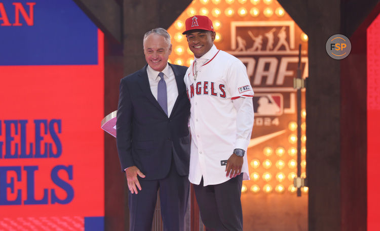Jul 14, 2024; Ft. Worth, TX, USA;  Christian Moore is congratulated by MLB commissioner Rob Manfred after being selected by the Los Angeles Angels as the eight player taken during the first round of the MLB Draft at Cowtown Coliseum. Credit: Kevin Jairaj-USA TODAY Sports