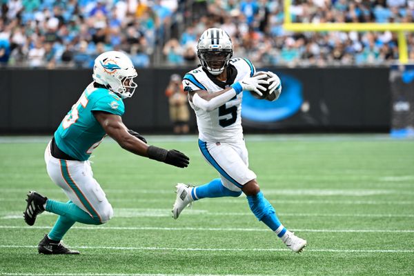 Oct 5, 2025; Charlotte, North Carolina, USA; Carolina Panthers running back Rico Dowdle (5) with the ball as Miami Dolphins linebacker Tyrel Dodson (25) defends in the second quarter at Bank of America Stadium. Mandatory Credit: Bob Donnan-Imagn Images