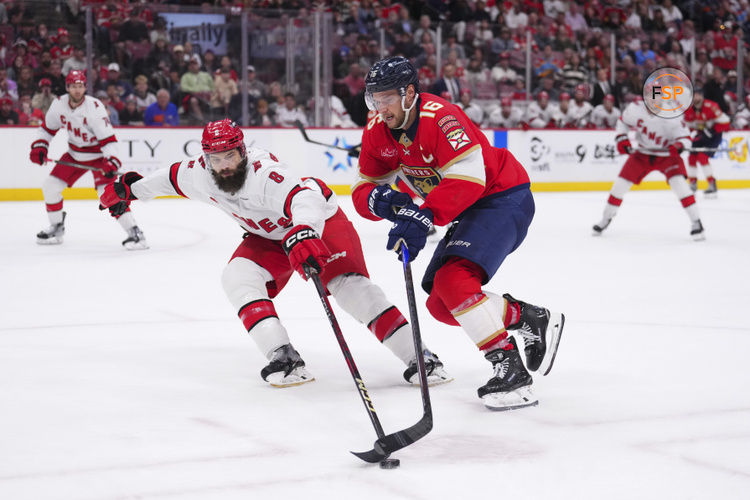 Jan 2, 2025; Sunrise, Florida, USA; Florida Panthers center Aleksander Barkov (16) skates the puck up the ice against Carolina Hurricanes defenseman Brent Burns (8) during the third period at Amerant Bank Arena. Credit: Rich Storry-Imagn Images