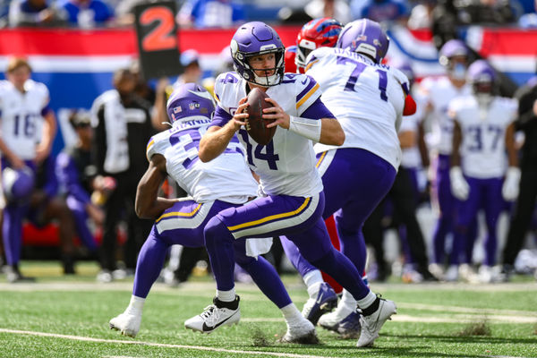 Sep 8, 2024; East Rutherford, New Jersey, USA; Minnesota Vikings quarterback Sam Darnold (14) rolls out to pass against the New York Giants during the second half at MetLife Stadium. Mandatory Credit: John Jones-Imagn Images