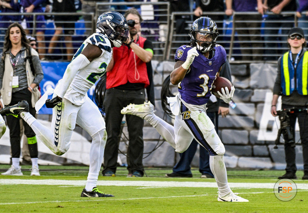 BALTIMORE, MD - NOVEMBER 05:  Baltimore Ravens running back Keaton Mitchell (34) runs for a touchdown  against Seattle Seahawks cornerback Riq Woolen (27) during the Seattle Seahawks game versus the Baltimore Ravens on November 5, 2023 at M&T Bank Stadium in Baltimore, MD.  (Photo by Mark Goldman/Icon Sportswire)
