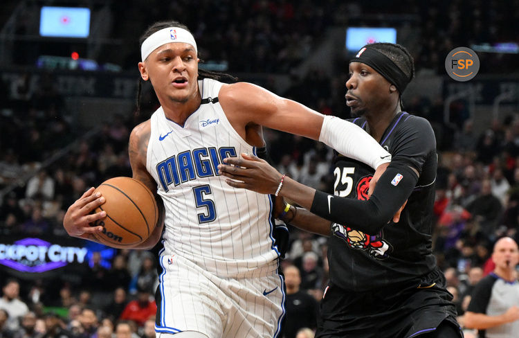 Jan 21, 2025; Toronto, Ontario, CAN;  Orlando Magic forward Paolo Banchero (5) pushes off Toronto Raptors forward Chris Boucher (25) in the first half at Scotiabank Arena. Credit: Dan Hamilton-Imagn Images