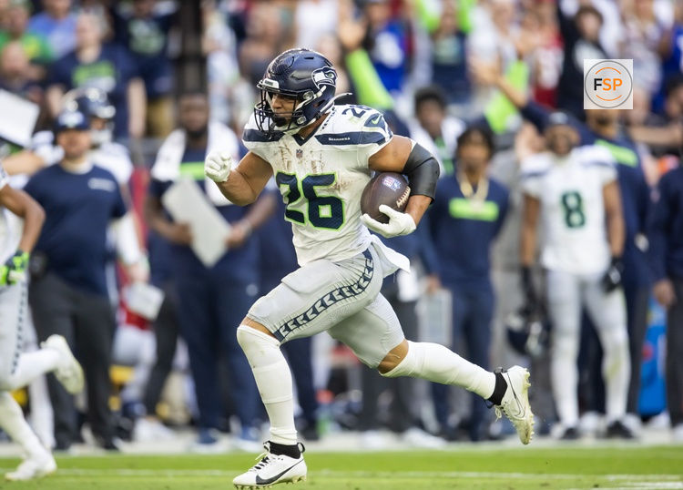 Dec 8, 2024; Glendale, Arizona, USA; Seattle Seahawks running back Zach Charbonnet (26) runs for a touchdown against the Arizona Cardinals in the first half at State Farm Stadium. Credit: Mark J. Rebilas-Imagn Images