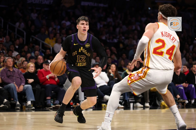 Jan 13, 2026; Los Angeles, California, USA;  Los Angeles Lakers forward Jake LaRavia (12) drives to the basket against Atlanta Hawks forward Corey Kispert (24) during the fourth quarter at Crypto.com Arena. Credit: Kiyoshi Mio-Imagn Images