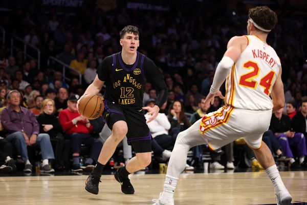 Jan 13, 2026; Los Angeles, California, USA;  Los Angeles Lakers forward Jake LaRavia (12) drives to the basket against Atlanta Hawks forward Corey Kispert (24) during the fourth quarter at Crypto.com Arena. Mandatory Credit: Kiyoshi Mio-Imagn Images