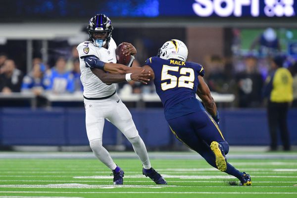 Nov 25, 2024; Inglewood, California, USA; Baltimore Ravens quarterback Lamar Jackson (8) runs the ball against Los Angeles Chargers linebacker Khalil Mack (52) during the second half at SoFi Stadium. Mandatory Credit: Gary A. Vasquez-Imagn Images