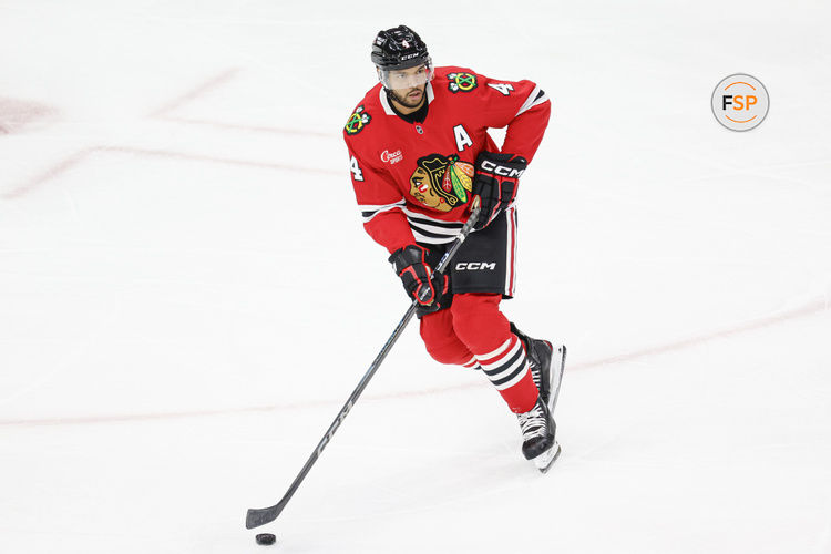 Jan 13, 2025; Chicago, Illinois, USA; Chicago Blackhawks defenseman Seth Jones (4) looks to pass the puck against the Calgary Flames during the second period at United Center. Credit: Kamil Krzaczynski-Imagn Images