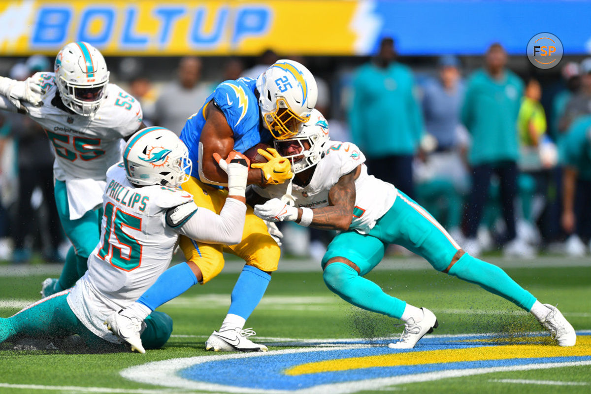 INGLEWOOD, CA - SEPTEMBER 10: Los Angeles Chargers running back Joshua Kelley (25) is hit by Miami Dolphins linebacker Jaelan Phillips (15) and Miami Dolphins safety DeShon Elliott (21) during the NFL regular season game between the Miami Dolphins and the Los Angeles Chargers on September 10, 2023, at SoFi Stadium in Inglewood, CA. (Photo by Brian Rothmuller/Icon Sportswire)