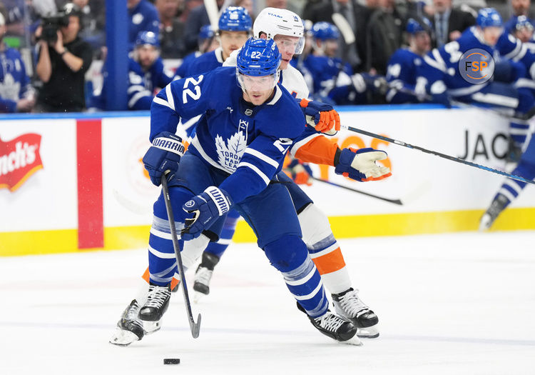 Dec 31, 2024; Toronto, Ontario, CAN;Toronto Maple Leafs defenseman Jake McCabe (22) battles for the puck with New York Islanders center Bo Horvat (14) during the second period at the Scotiabank Arena. Credit: Nick Turchiaro-Imagn Images