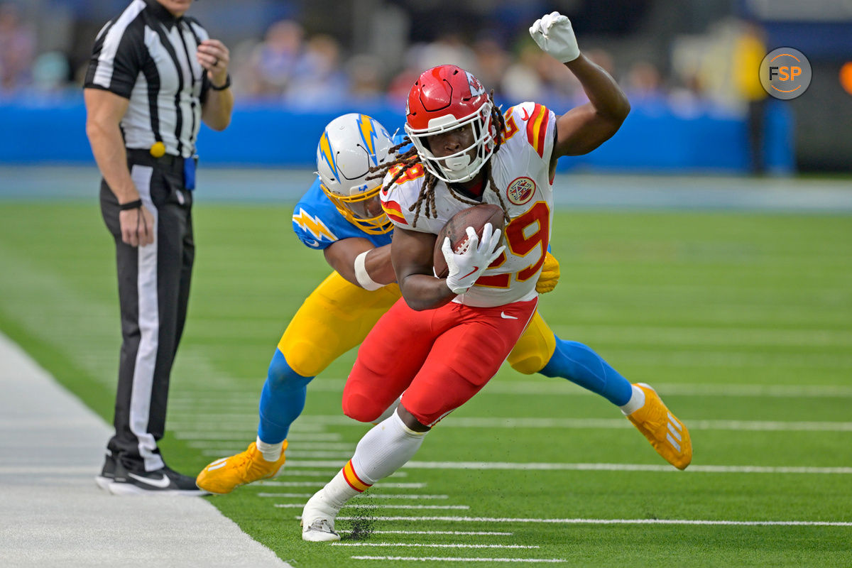 Sep 29, 2024; Inglewood, California, USA;  Kansas City Chiefs running back Kareem Hunt (29) runs for a first down before he is forced out of bounds by Los Angeles Chargers linebacker Daiyan Henley (0) in the second half at SoFi Stadium. Credit: Jayne Kamin-Oncea-Imagn Images