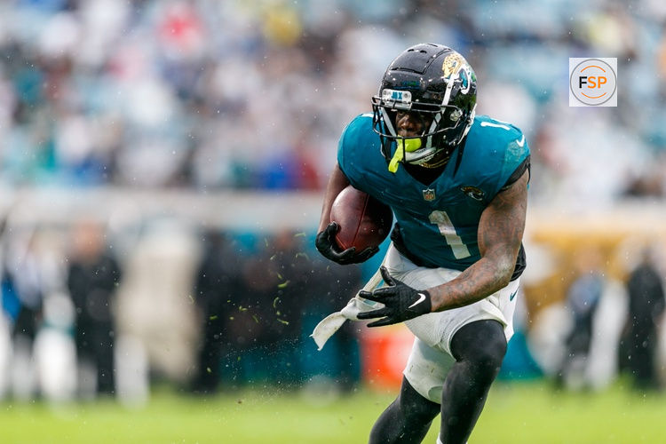 Dec 29, 2024; Jacksonville, Florida, USA; Jacksonville Jaguars running back Travis Etienne Jr. (1) runs the ball against the Tennessee Titans during the second quarter at EverBank Stadium. Credit: Morgan Tencza-Imagn Images