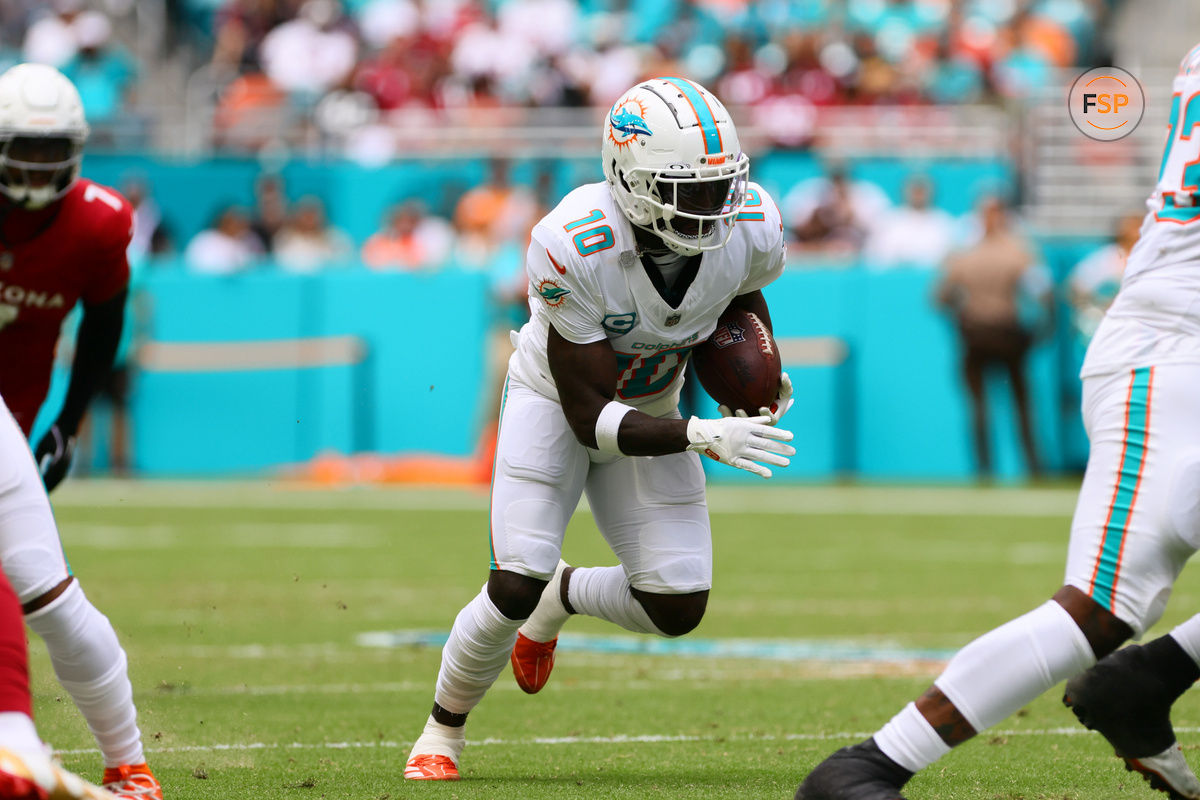 Oct 27, 2024; Miami Gardens, Florida, USA; Miami Dolphins wide receiver Tyreek Hill (10) runs with the football against the Arizona Cardinals during the first quarter at Hard Rock Stadium. Credit: Sam Navarro-Imagn Images