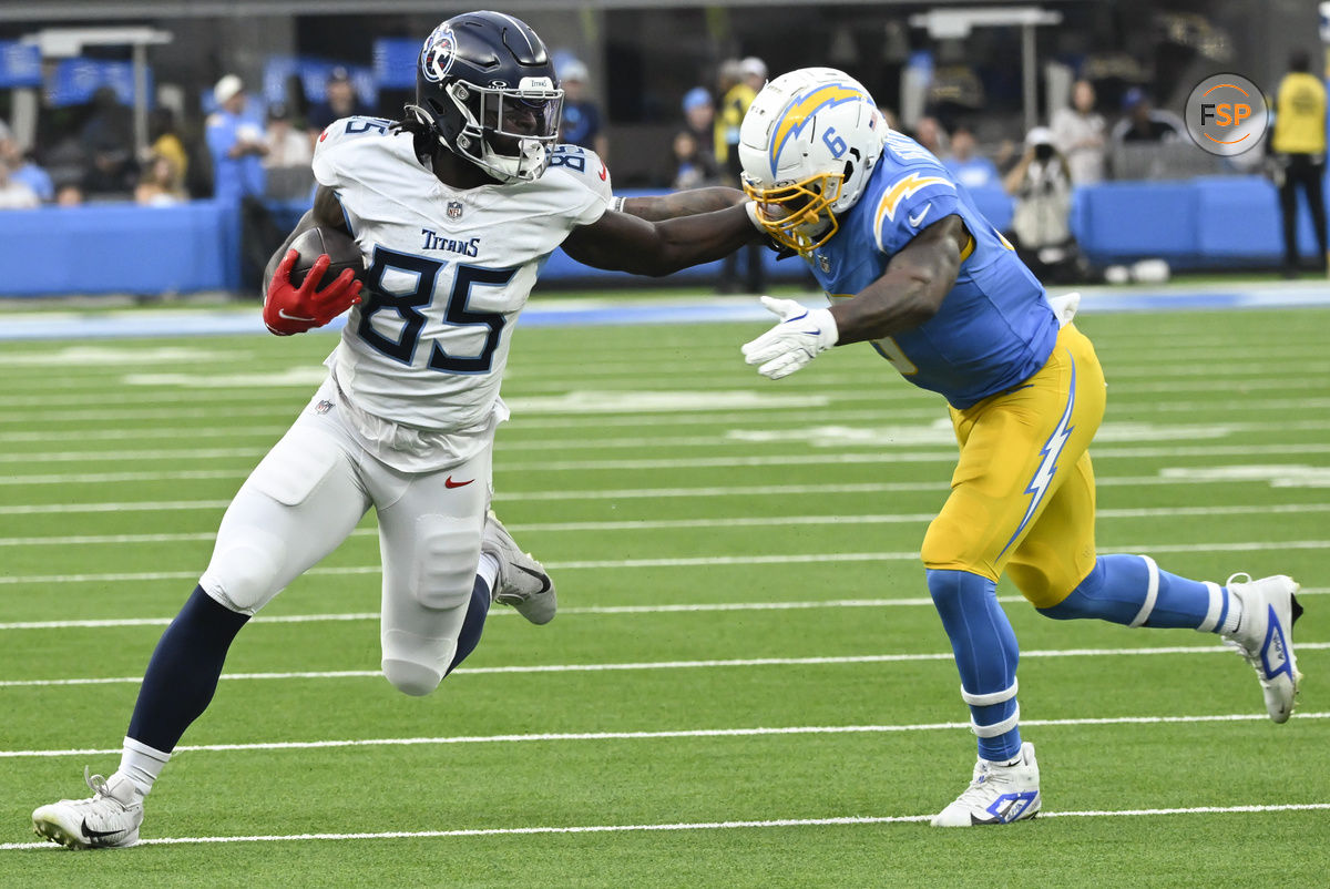 Nov 10, 2024; Inglewood, California, USA; Tennessee Titans tight end Chig Okonkwo (85) stiff arms Los Angeles Chargers linebacker Denzel Perryman (6) during the third quarter at SoFi Stadium. Credit: Robert Hanashiro-Imagn Images