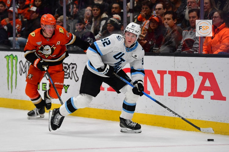 Dec 3, 2025; Anaheim, California, USA; Utah Mammoth center Logan Cooley (92) moves the puck ahead of Anaheim Ducks defenseman Jackson Lacombe (2) during the second period at Honda Center. Credit: Gary A. Vasquez-Imagn Images