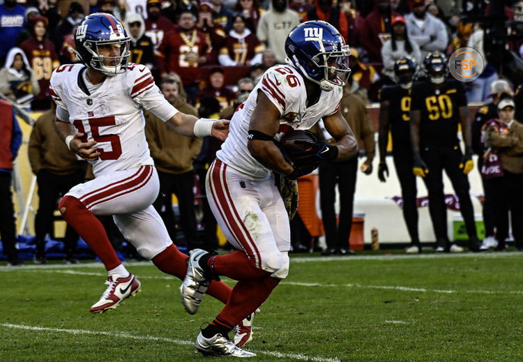 LANDOVER, MD - NOVEMBER 19: New York Giants quarterback Tommy DeVito (15) hands the ball off to running back Saquon Barkley (26) during the NFL game between the New York Giants and the Washington Commanders on November 19, 2023 at Fed Ex Field in Landover, MD. (Photo by Mark Goldman/Icon Sportswire)