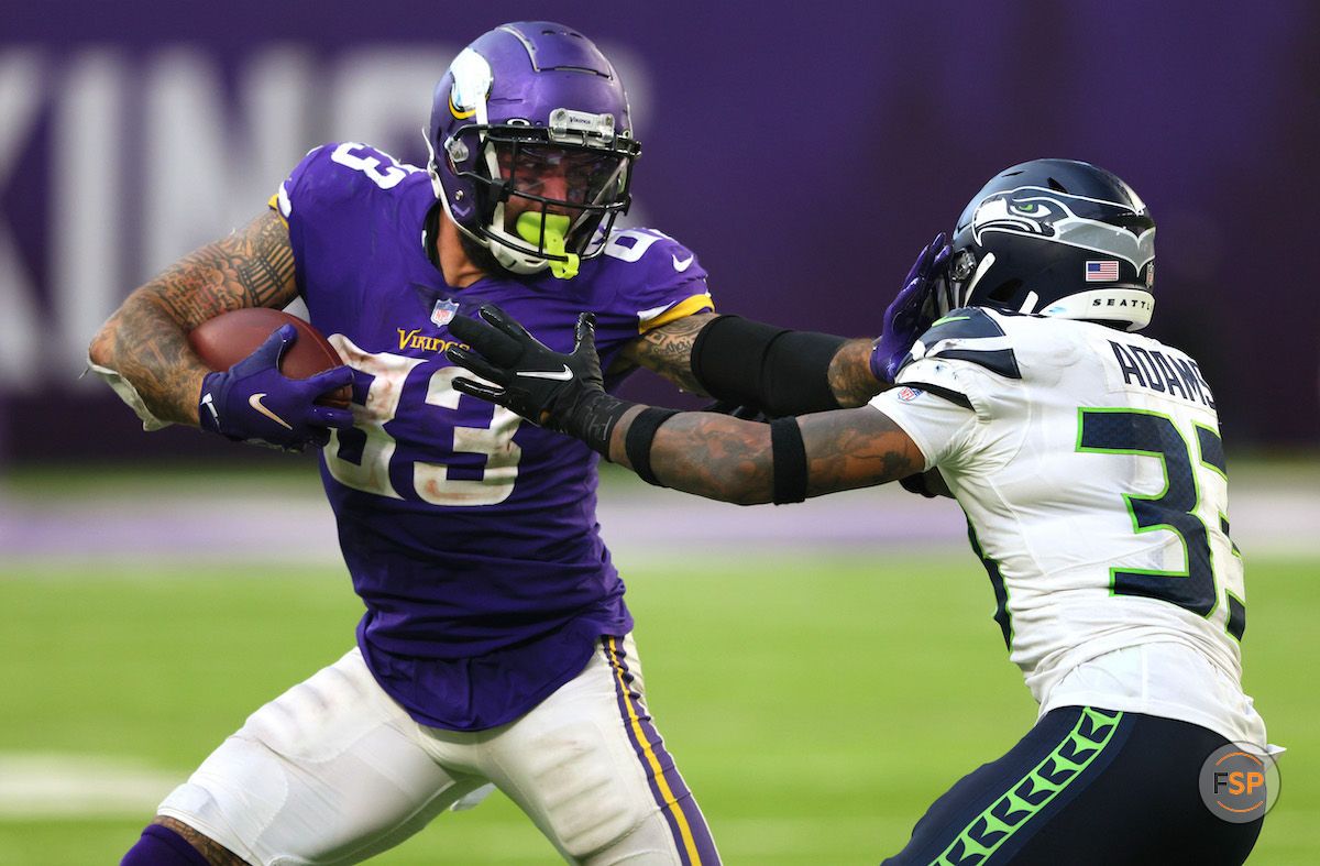 MINNEAPOLIS, MINNESOTA - SEPTEMBER 26: Tyler Conklin #83 of the Minnesota Vikings carries the ball for a first down as he tries to avoid a tackle by Jamal Adams #33 of the Seattle Seahawks in the game at U.S. Bank Stadium on September 26, 2021 in Minneapolis, Minnesota. (Photo by Adam Bettcher/Getty Images)