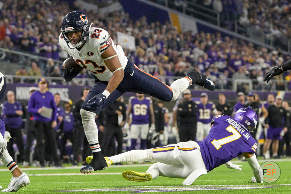 MINNEAPOLIS, MN - NOVEMBER 27: Chicago Bears running back Roschon Johnson (23) leaps over Minnesota Vikings defensive back Byron Murphy (7) during the second quarter of an NFL game between the Minnesota Vikings and Chicago Bears on November 27, 2023, at U.S. Bank Stadium in Minneapolis, MN. (Photo by Nick Wosika/Icon Sportswire)