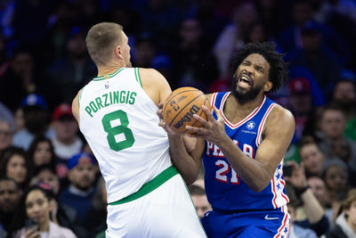 Feb 20, 2025; Philadelphia, Pennsylvania, USA; Philadelphia 76ers center Joel Embiid (21) is fouled by Boston Celtics center Kristaps Porzingis (8) during the second quarter at Wells Fargo Center. Mandatory Credit: Bill Streicher-Imagn Images