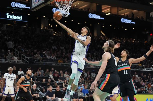 Feb 21, 2026; Austin, Texas, USA;  Sacramento Kings guard Nique Clifford (5) shoots in front of San Antonio Spurs forwards Kelly Olynyk (8) and Carter Bryant (11) in the second half at Moody Center. Mandatory Credit: Daniel Dunn-Imagn Images