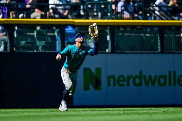 DENVER, CO - APRIL 21: Seattle Mariners outfielder Jonatan Clase (5) catches a fly ball in the eighth inning during a game between the Seattle Mariners and the Colorado Rockies at Coors Field on April 21, 2024 in Denver, Colorado. (Photo by Dustin Bradford/Icon Sportswire)