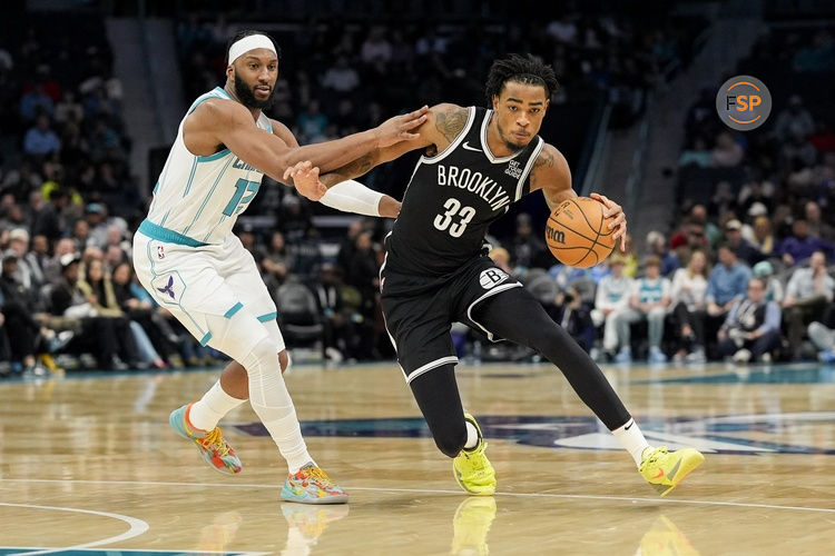 Jan 29, 2025; Charlotte, North Carolina, USA; Brooklyn Nets center Nic Claxton (33) handles the ball guarded by Charlotte Hornets forward Josh Okogie (12) during the second quarter at Spectrum Center. Credit: Jim Dedmon-Imagn Images