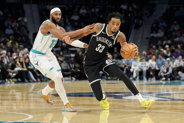 Jan 29, 2025; Charlotte, North Carolina, USA; Brooklyn Nets center Nic Claxton (33) handles the ball guarded by Charlotte Hornets forward Josh Okogie (12) during the second quarter at Spectrum Center. Mandatory Credit: Jim Dedmon-Imagn Images