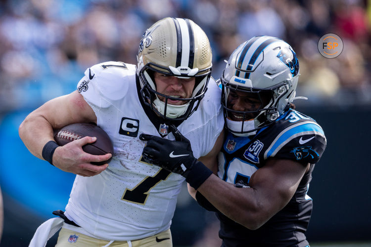 Nov 3, 2024; Charlotte, North Carolina, USA; New Orleans Saints tight end Taysom Hill (7) is hit by Carolina Panthers safety Demani Richardson (36) during the first quarter at Bank of America Stadium. Credit: Scott Kinser-Imagn Images