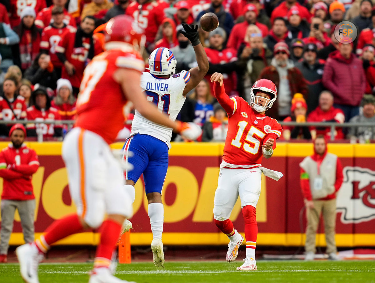 Dec 10, 2023; Kansas City, Missouri, USA; Kansas City Chiefs quarterback Patrick Mahomes (15) throws a pass to tight end Travis Kelce (87) as Buffalo Bills defensive tackle Ed Oliver (91) defends during the first half at GEHA Field at Arrowhead Stadium. Credit: Jay Biggerstaff-USA TODAY Sports