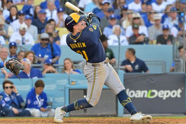 Oct 16, 2025; Los Angeles, California, USA; Milwaukee Brewers third baseman Caleb Durbin (21) hits a double against the Los Angeles Dodgers in the seventh inning during game three of the NLCS round for the 2025 MLB playoffs at Dodger Stadium. Mandatory Credit: Jayne Kamin-Oncea-Imagn Images