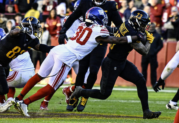 LANDOVER, MD - NOVEMBER 19: Washington Commanders running back Chris Rodriguez Jr. (23) is brought down by New York Giants cornerback Darnay Holmes (30) during the NFL game between the New York Giants and the Washington Commanders on November 19, 2023 at Fed Ex Field in Landover, MD. (Photo by Mark Goldman/Icon Sportswire)