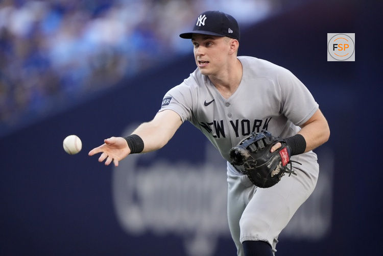 Oct 5, 2025; Toronto, Ontario, CAN; New York Yankees first baseman Ben Rice (22) tosses to first for an out in the third inning against the Toronto Blue Jays during game two of the ALDS round for the 2025 MLB playoffs at Rogers Centre. Credit: John E. Sokolowski-Imagn Images