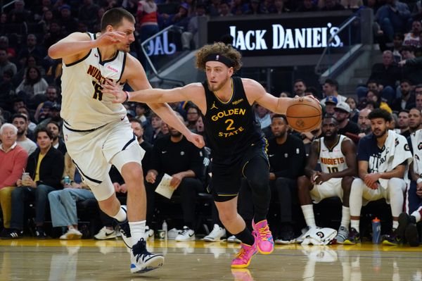 Feb 22, 2026; San Francisco, California, USA;  Golden State Warriors guard Brandin Podziemski (2) drives to the basket against Denver Nuggets center Nikola Jokic (15) in the second quarter at Chase Center. Mandatory Credit: David Gonzales-Imagn Images