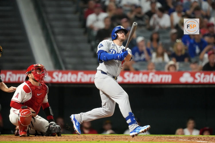 Aug 11, 2025; Anaheim, California, USA; Los Angeles Dodgers third baseman Max Muncy (13) hits a three-run home run in the eighth inning as Los Angeles Angels catcher Travis d'Arnaud (25) watches at Angel Stadium. Credit: Kirby Lee-Imagn Images