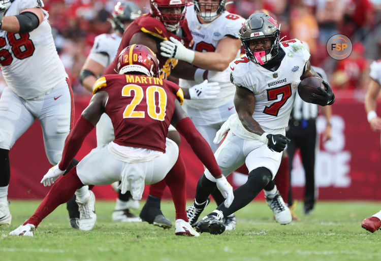 Sep 8, 2024; Tampa, Florida, USA;  Tampa Bay Buccaneers running back Bucky Irving (7) runs with the ball as Washington Commanders safety Quan Martin (20) defends during the second half at Raymond James Stadium. Credit: Kim Klement Neitzel-Imagn Images