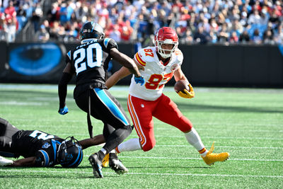 Nov 24, 2024; Charlotte, North Carolina, USA; Kansas City Chiefs tight end Travis Kelce (87) with the ball as Carolina Panthers cornerback Michael Jackson (2) and safety Jordan Fuller (20) defend in the first quarter at Bank of America Stadium. Mandatory Credit: Bob Donnan-Imagn Images