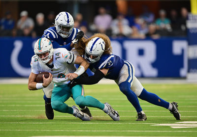 Oct 20, 2024; Indianapolis, Indiana, USA; Miami Dolphins quarterback Tim Boyle (14) is tackled by Indianapolis Colts defensive end Dayo Odeyingbo (54) and linebacker Grant Stuard (41) during the second half at Lucas Oil Stadium. Mandatory Credit: Marc Lebryk-Imagn Images