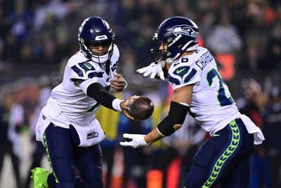 Dec 26, 2024; Chicago, Illinois, USA; Seattle Seahawks quarterback Geno Smith (7) hands the ball to running back Zach Charbonnet (26) against the Chicago Bears during the first quarter at Soldier Field. Mandatory Credit: Daniel Bartel-Imagn Images