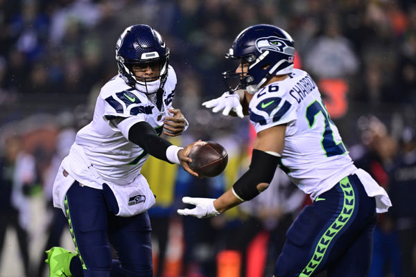 Dec 26, 2024; Chicago, Illinois, USA; Seattle Seahawks quarterback Geno Smith (7) hands the ball to running back Zach Charbonnet (26) against the Chicago Bears during the first quarter at Soldier Field. Mandatory Credit: Daniel Bartel-Imagn Images