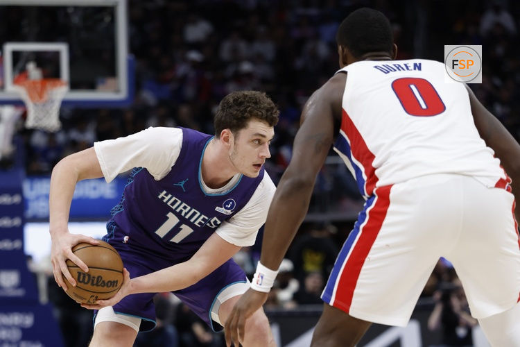 Dec 20, 2025; Detroit, Michigan, USA;  Charlotte Hornets center Ryan Kalkbrenner (11) is defended by Detroit Pistons center Jalen Duren (0) in the second half at Little Caesars Arena. Credit: Rick Osentoski-Imagn Images
